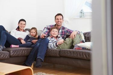 Familie entspannt drinnen beim Fernsehen zusammen