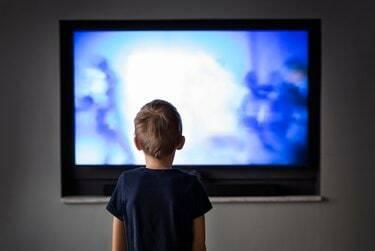 Малко момче гледа телевизия