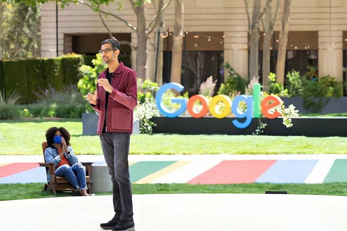 Ο Sundar Pichai στέκεται μπροστά από ένα λογότυπο της Google στο Google IO 2021.