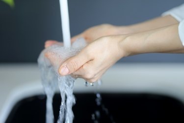 Moteris plauna rankas praustuvėje